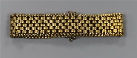A yellow metal brick link bracelet.